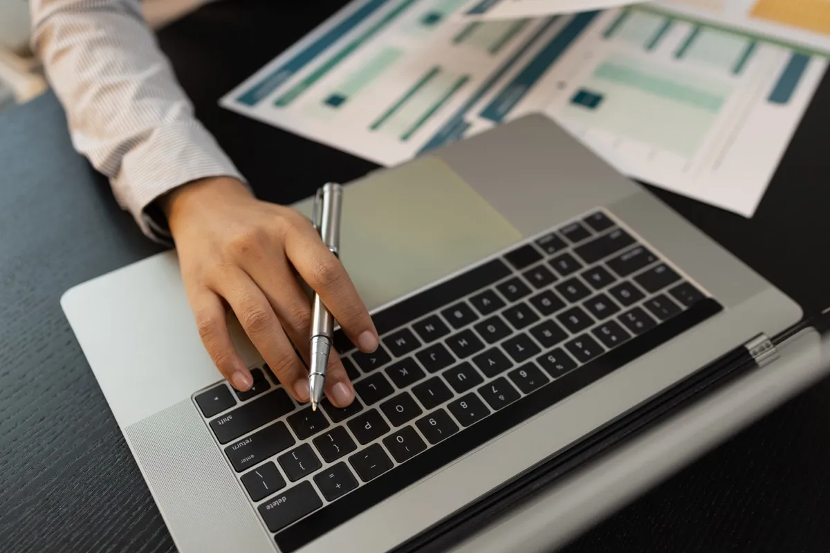 Firmendaten im Abgleich: Unterlagen werden am Laptop geprüft