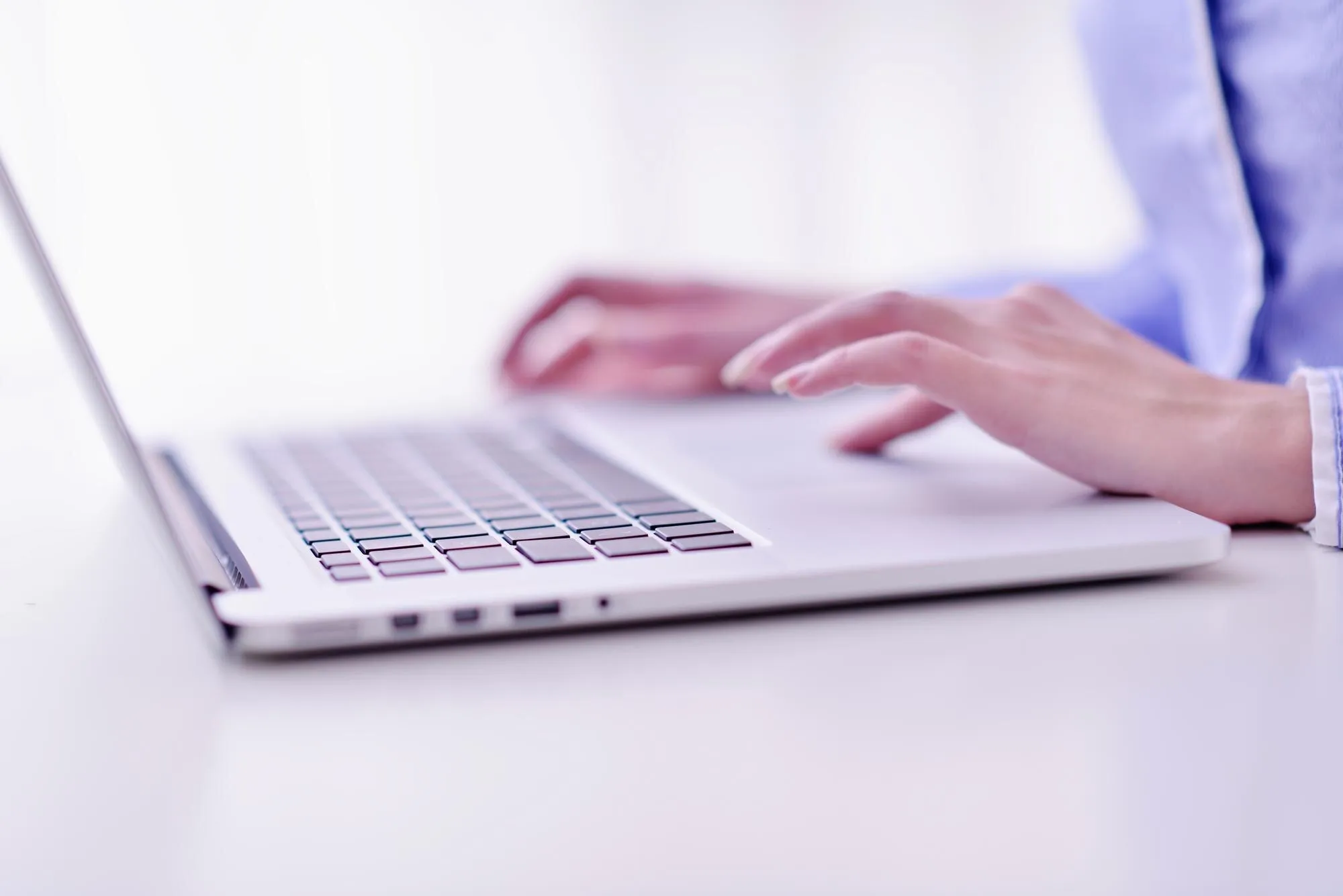 Arbeiten mit dem KI-Assistenten: Unternehmer am Laptop, daneben ein kleiner Roboter
