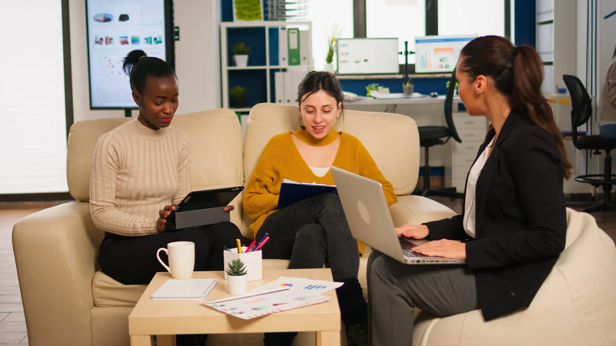 Kreativteam bespricht ein Website-Projekt mit Laptop und Tablet im Büro