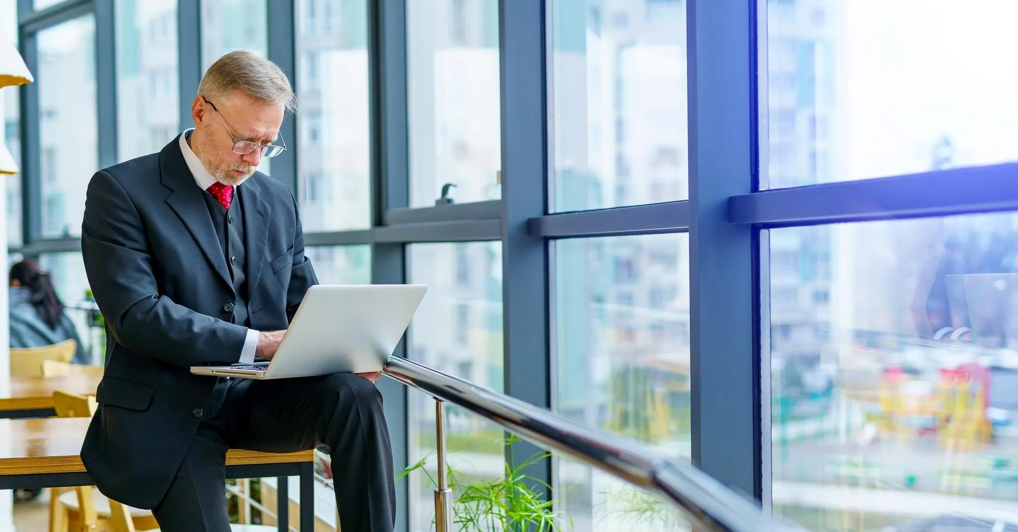 Wachsendes Team arbeitet gemeinsam an mehreren Arbeitsplätzen in einem modernen Büro