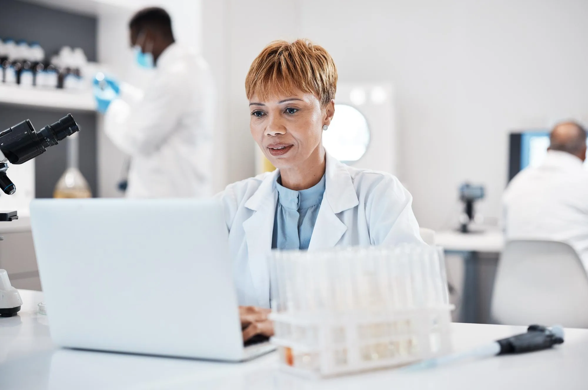 Wissenschaftlerin am Laptop im Labor: Sicherheitsnachweise für Auftraggeber aus Pharma und Forschung