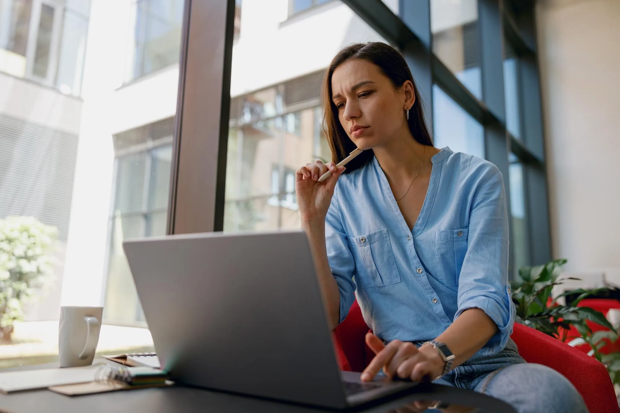 Nachdenkliche Unternehmerin am Laptop wägt eine Entscheidung ab