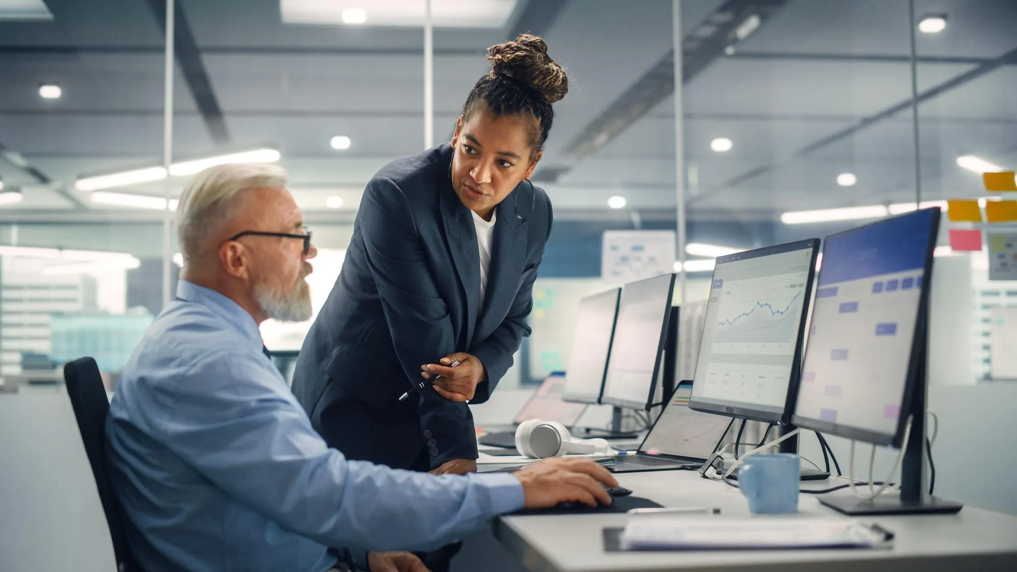 Beraterin und Unternehmer prüfen gemeinsam die Kennzahlen einer Cloud-ERP-Lösung am Bildschirm