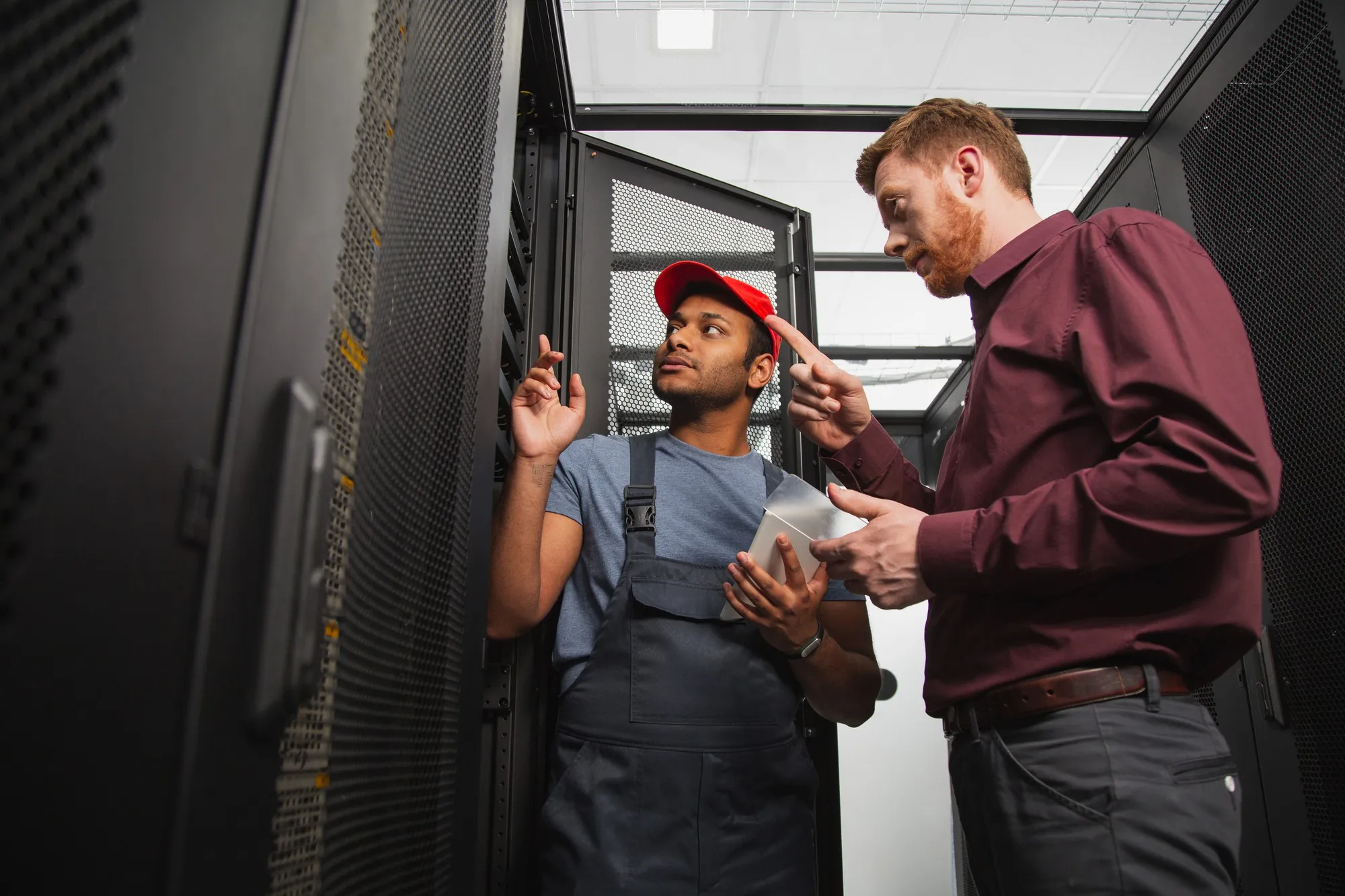 Techniker und Verantwortlicher besprechen die alternde Server-Hardware im Serverraum