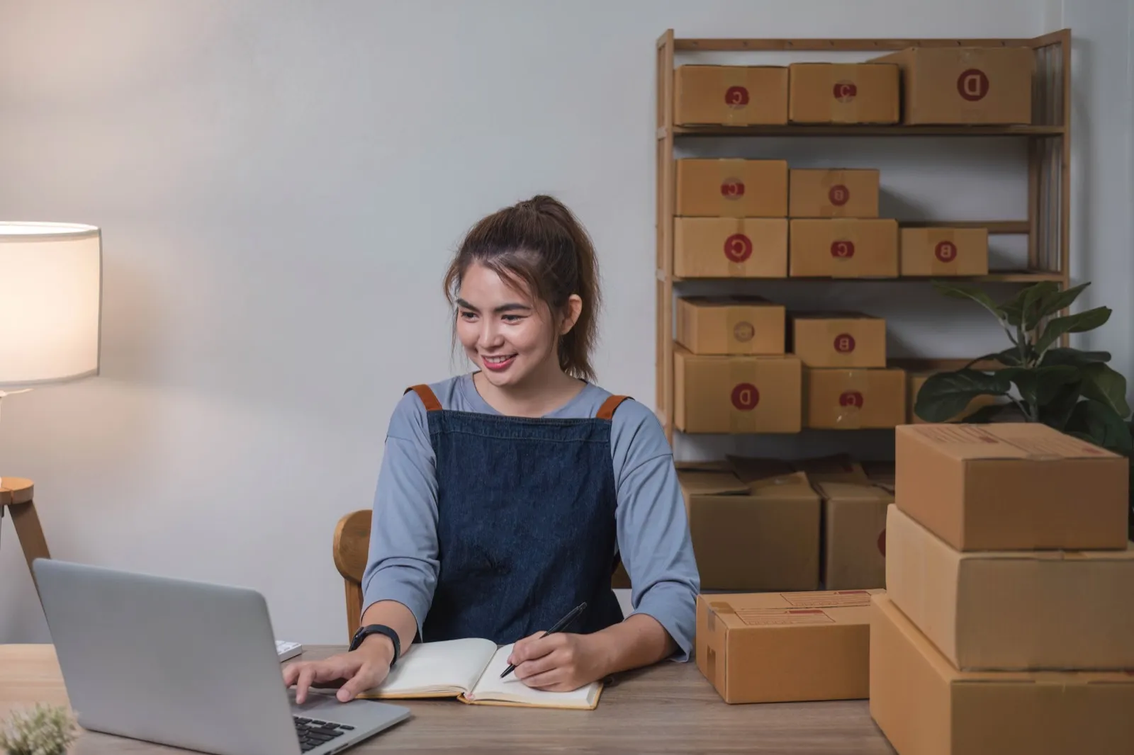 Shop-Betreiberin bereitet Bestellungen ihres Onlineshops für den Versand vor