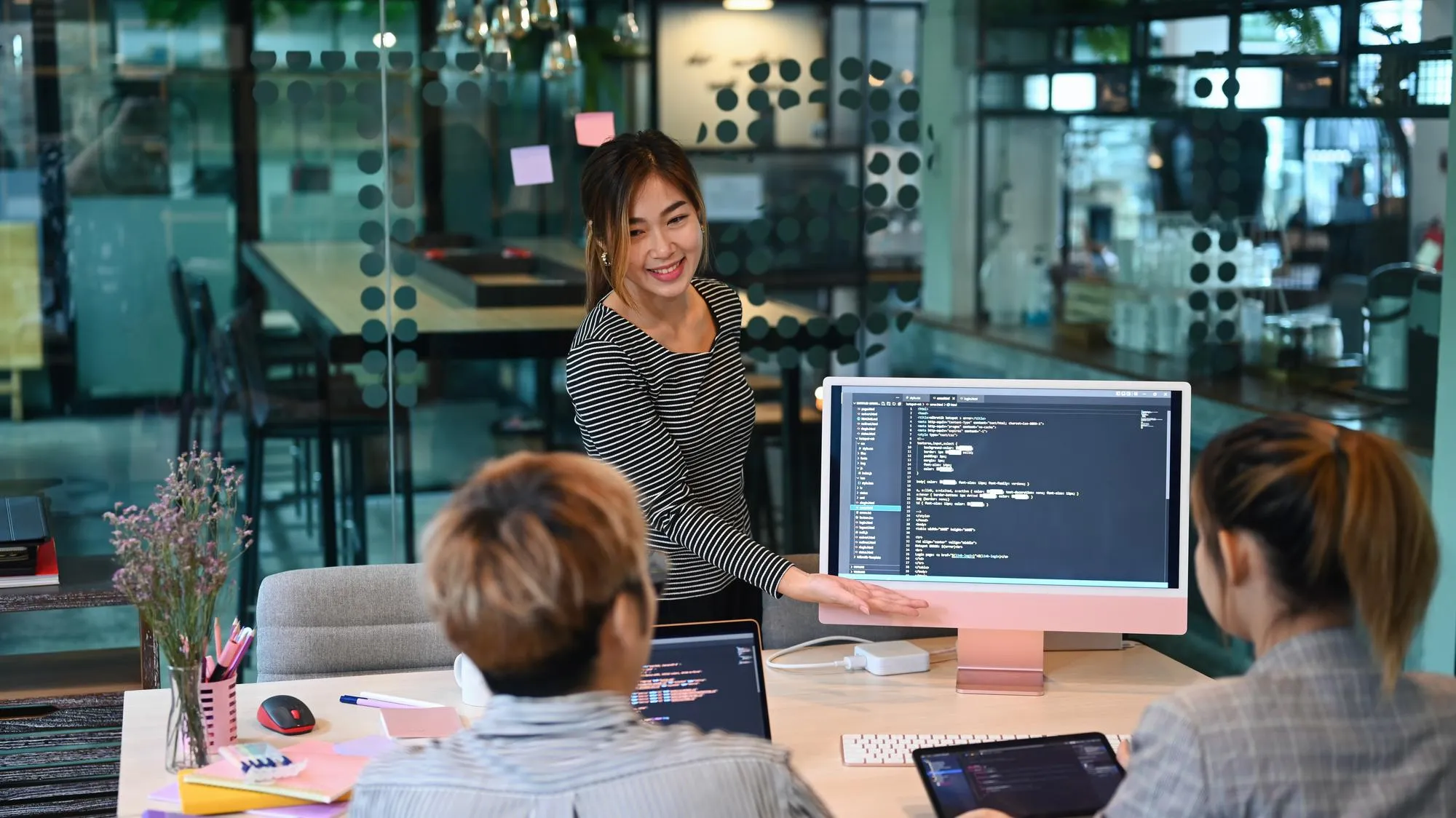 Entwicklerteam bespricht weclapp-Erweiterungen am Bildschirm mit Programmcode