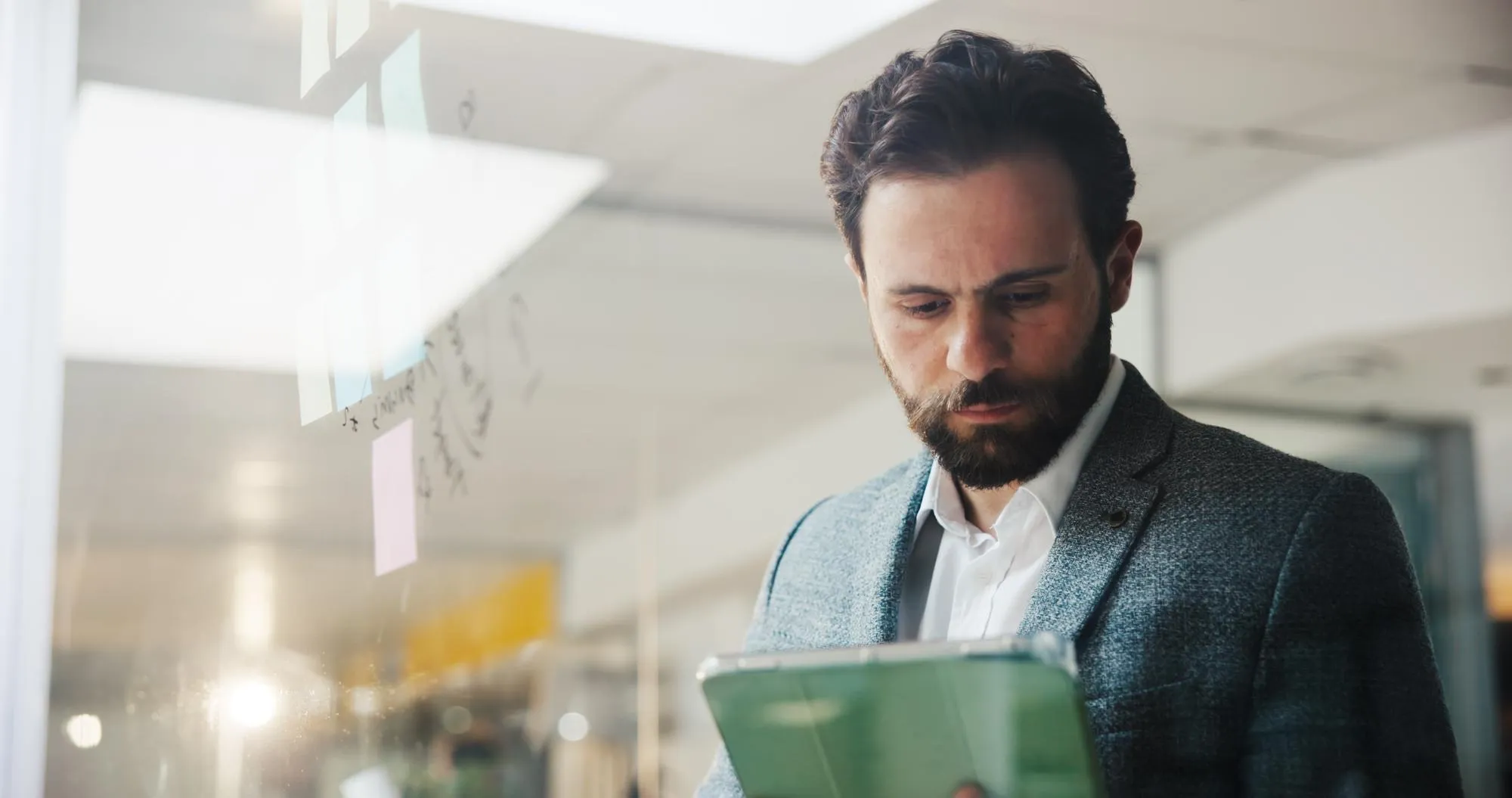 Entscheider arbeitet mit Tablet und Planungsboard, Wissen für bessere Entscheidungen