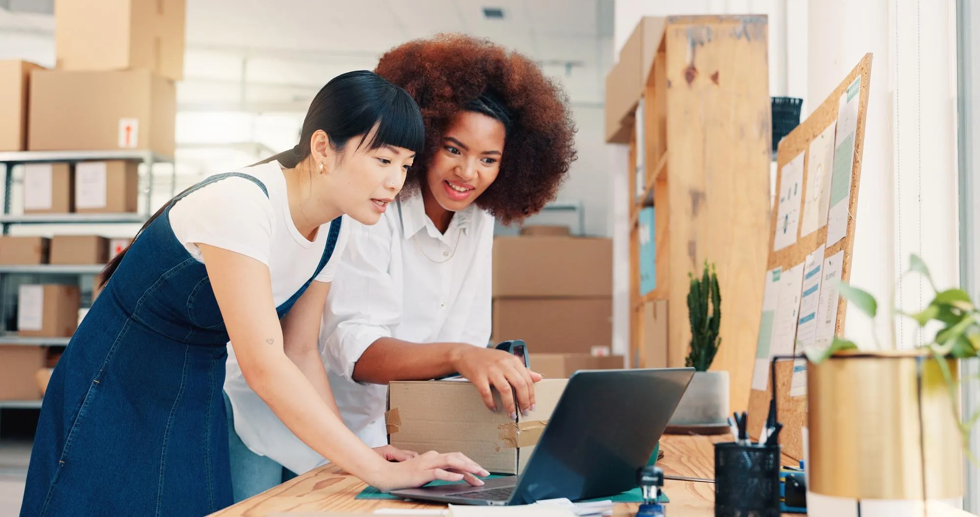 Team im E-Commerce-Lager plant am Laptop den Umstieg auf ein Cloud-ERP